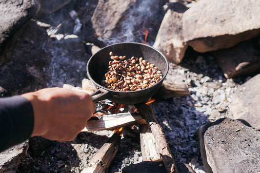 a person is cooking food over a campfire