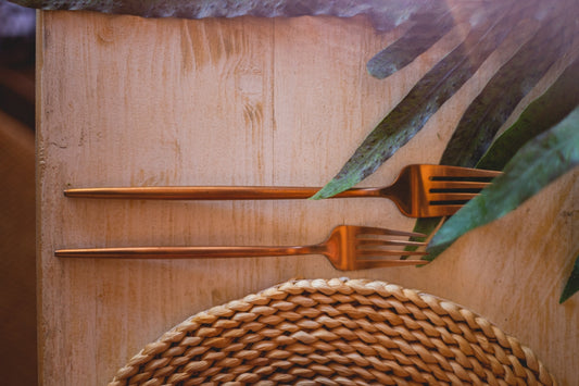 a wooden cutting board topped with a knife and fork