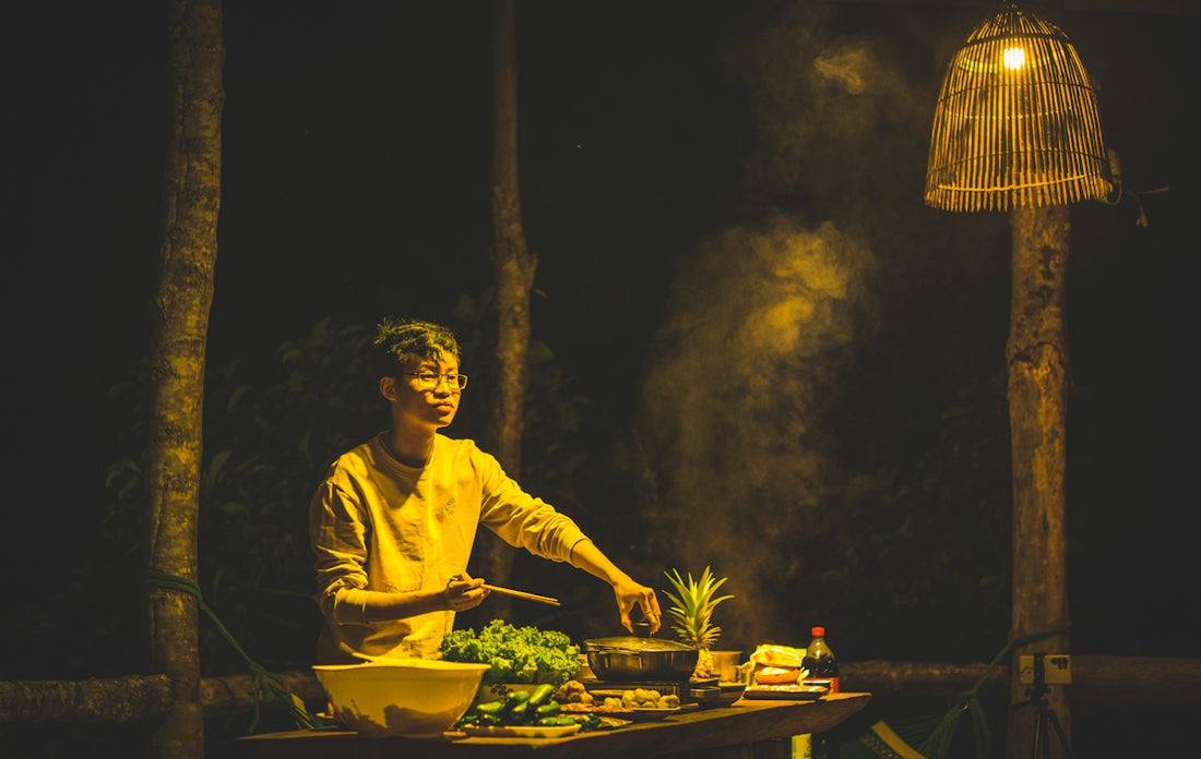 A person cooking food on a grill in the dark