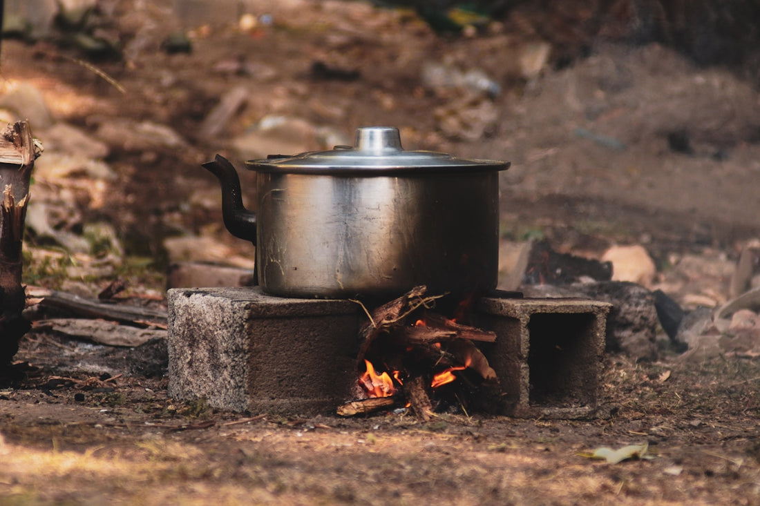 Metal pot cooking over an open fire