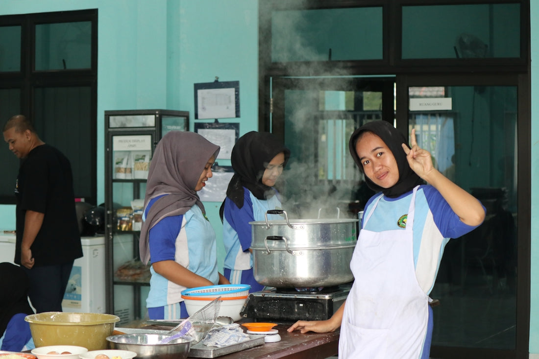 Young people cooking and steaming food in a kitchen.