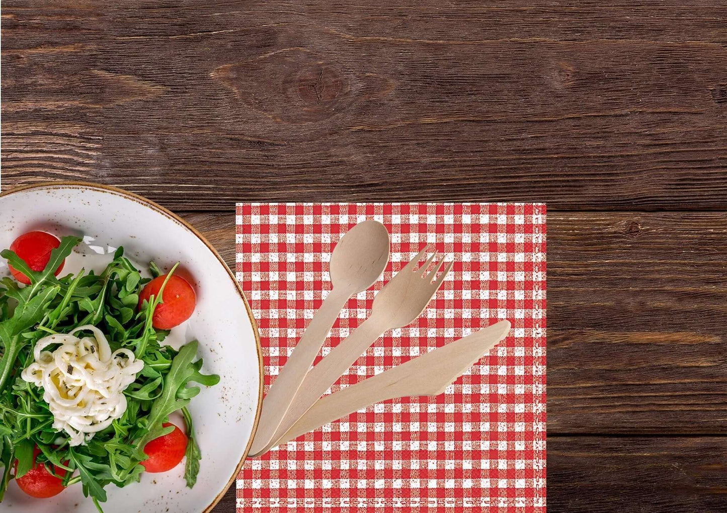 Bosnal Wooden Disposable Cutlery Set - 100 Pcs Biodegradable Compostable Utensils next to a salad on a checkered napkin.
